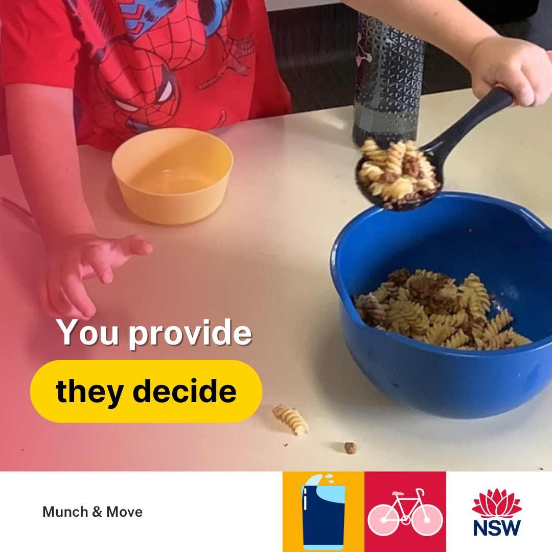 young child's hands using a ladle to scoop pasta from blue pot for a pale yellow bowl