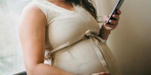 Quit4Bub. A pregnant woman with mobile phone in hand.