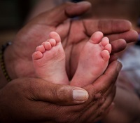 Adult hands holding baby feet