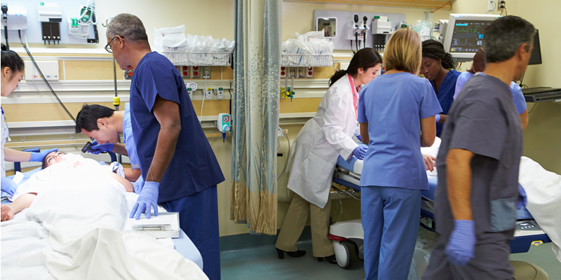 Nurses in hospital around a patient's bed