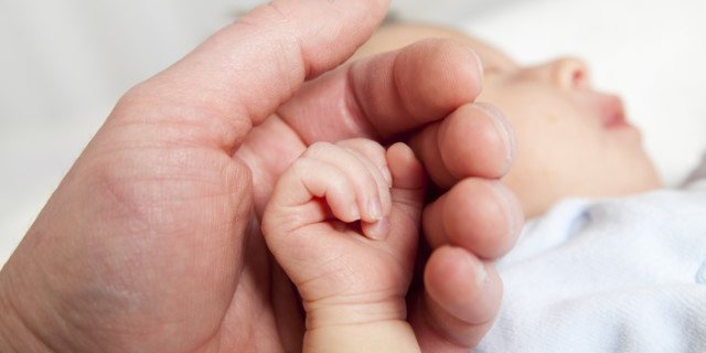 Mother holding new born baby hand