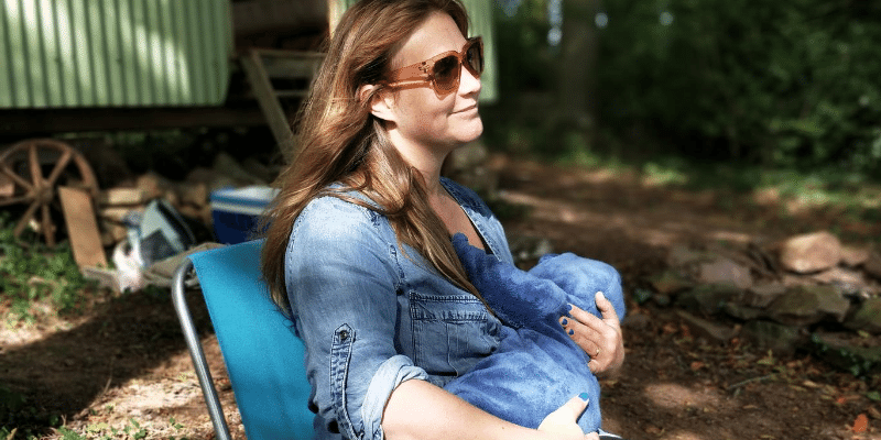 Woman sitting on a bench breastfeeding her baby