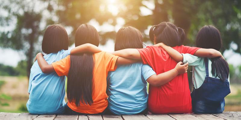 A group of five children sitting together in a park