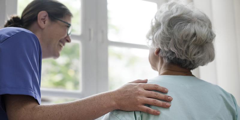 image of a nurse with her hand on the shoulder of an elderly patient